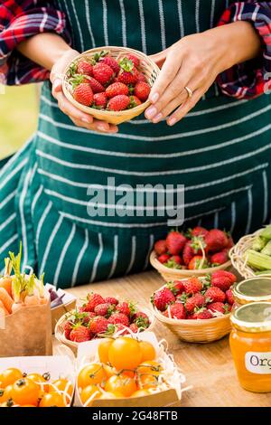Midsection of woman selling strawberries Stock Photo