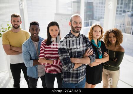 Business executives standing with arms crossed in office Stock Photo