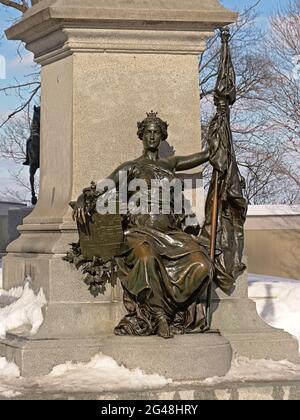 Bronze statue of a crowned woman holding a shield surrounded with maple leafs and a flag, found on Parliament hill, Ottawa, capital city of Canada Stock Photo