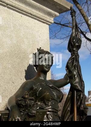 Bronze statue of a crowned woman holding a shield surrounded with maple leafs and a flag, found on Parliament hill, Ottawa, capital city of Canada Stock Photo