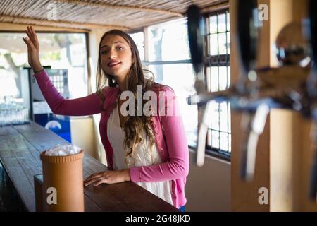 Young woman gesturing at bar Stock Photo