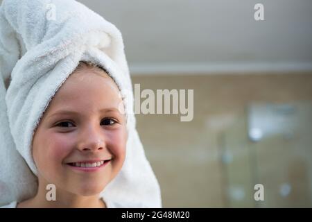 Portrait of smiling girl with hair wrapped in towel Stock Photo
