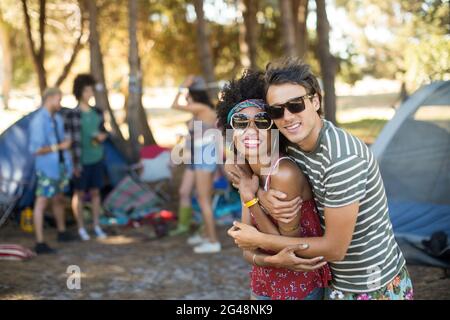 Portrait of friends embracing at campsite Stock Photo