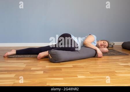 Pregnant woman lying in Shavasana, resting after practice, meditating Stock Photo