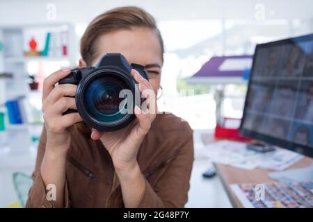 Female executive taking a photograph from digital camera Stock Photo