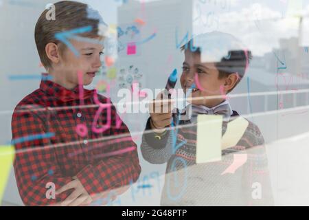 Kids as business executives discussing over whiteboard Stock Photo