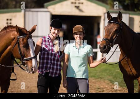 Portrait of smiling friends with horses Stock Photo