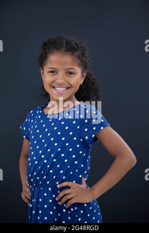 Girl with hand on hip relaxing in field Stock Photo - Alamy