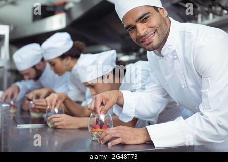 Chefs finishing dessert in glass at restaurant Stock Photo