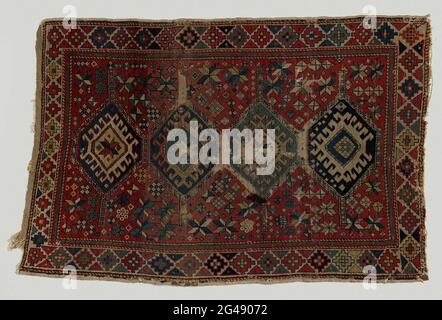 Carpet, Kazak, with medallion pattern. Carpet, Kazak, with medallion pattern. Midfield: On a red fond that is strewn with stars and cubes, four hexagonal medallions over the length axis, two of ultramarine, one of cobalt blue and one of light green with diamond and hook fillings. Borders: A white fond is divided into red, ultramarine, yellow, orange and greenery in diamond fields through lateral triangles, on which angular rosettes are located. Indoor zoom of interlocking triangles of red and green. Condition: with moths, larvae etc. arrived. Cleaned in the snow. With large ink stain. In the c Stock Photo