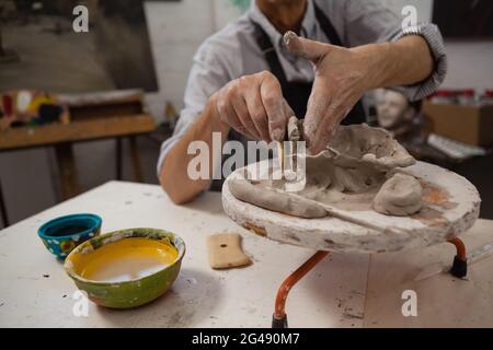 Mid-section of senior man molding clay Stock Photo