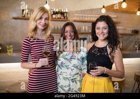 Portrait of female friends standing at counter Stock Photo