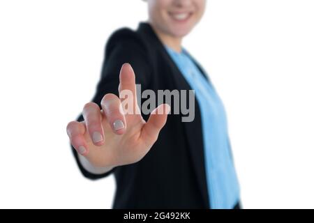 Mid section of smiling businesswoman touching imaginary interface Stock Photo