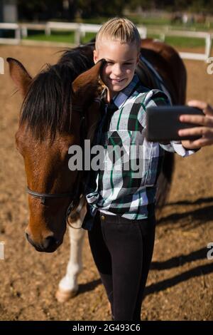 Girl taking a selfie with horse at the ranch Stock Photo - Alamy