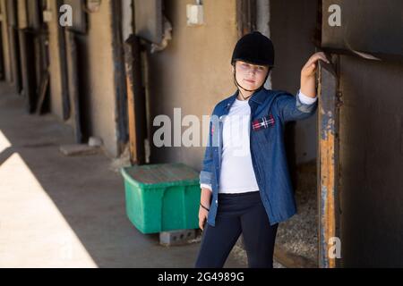 Girl standing in the stable Stock Photo