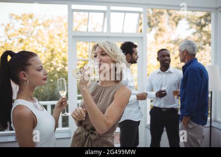 Friends interacting with each other while having champagne Stock Photo