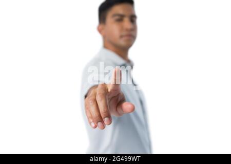 Man pretending to touch an invisible screen against white background Stock Photo