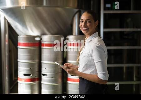 Smiling waitress using digital tablet in bar Stock Photo