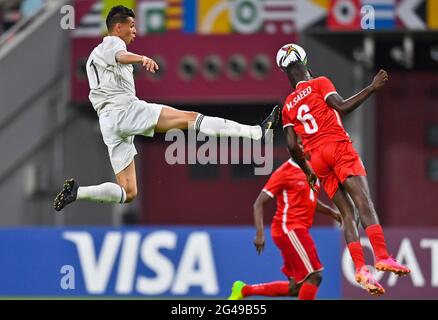 Doha, Qatar. 19th June, 2021. Mohamed Saeed (R) of Sudan vies with Mohamed Zubya of Libya during the FIFA Arab Cup Qatar 2021 qualifying round football match in Doha, Qatar, June 19, 2021. Credit: Nikku /Xinhua/Alamy Live News Stock Photo