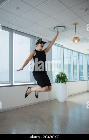 Female executive using virtual reality headset in office Stock Photo