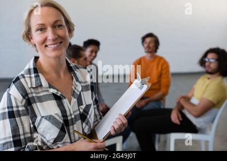 Portrait of smiling teacher with students in background Stock Photo