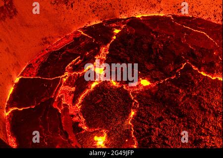 The surface of a hot liquid slag in a metallurgical ladle. Thick crust covered with trash net Stock Photo