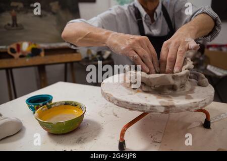 Mid-section of senior man molding clay Stock Photo