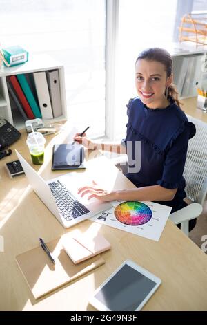 Female executive working over graphic tablet at her desk Stock Photo
