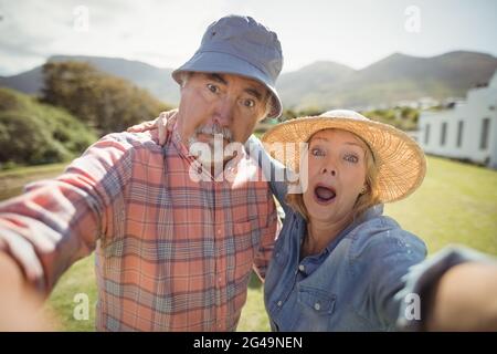 Senior couple making facial expression in garden Stock Photo