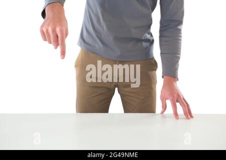 Mid section of creative businessman gesturing while standing at table Stock Photo