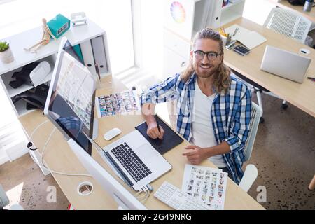 Portrait of male executive sitting at his desk Stock Photo
