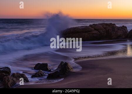 Waves crashing along the beach in Leo Carrillo State park at sunset Stock Photo