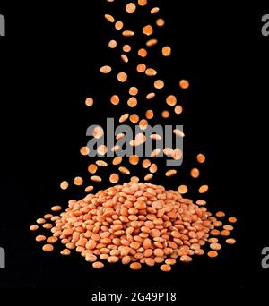 Heap of red lentils isolated on black background Stock Photo