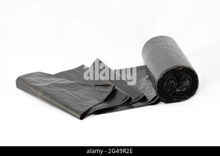 Black Polyethylene Garbage Bags on White Background - Close-Up. The Roll of Plastic Junk Package Stock Photo