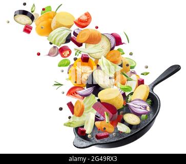 Different vegetables falling into frying pan on white background Stock Photo