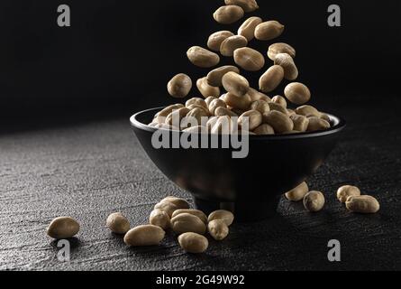 Falling peanut on black background with copy space Stock Photo