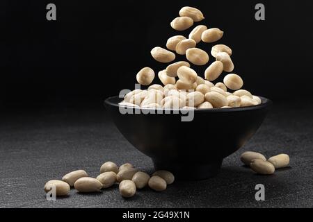 Falling peanut on black background with copy space Stock Photo