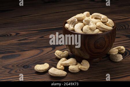 Cashew nuts in wooden bowl on black background Stock Photo