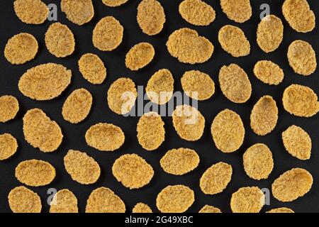 Pattern of corn flakes on black background, top view Stock Photo