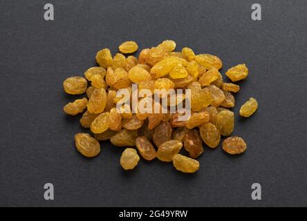 Dried yellow raisins on black background Stock Photo