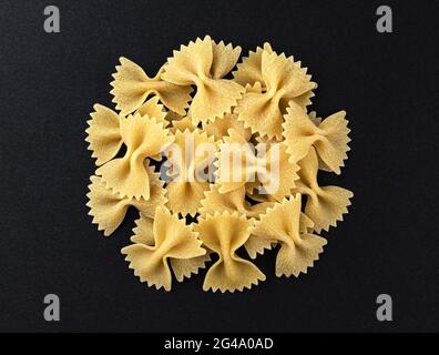 Raw farfalle pasta isolated on black background, top view Stock Photo