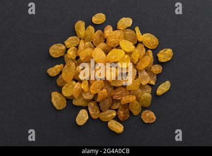 Pile of dried yellow raisins on black background Stock Photo