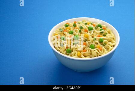 Bowl of instant noodles isolated on blue background Stock Photo
