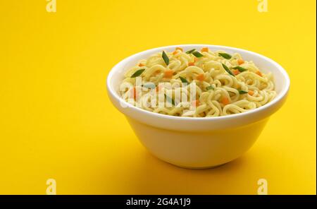 Bowl of instant noodles isolated on yellow background Stock Photo