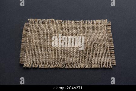 Old burlap fabric napkin on black background Stock Photo