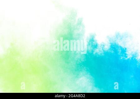 Abstract blue green powder explosion on white background.Freeze motion of blue green dust cloud. Stock Photo