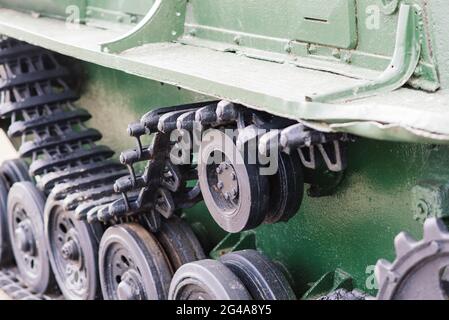 Fragment of a tracked track on a green camouflage tank. Stock Photo