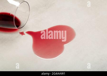 Wooden floor with overturned glass of red wine. Spilled wine on a wooden laminate parquet floor with moisture protection. High quality photo Stock Photo