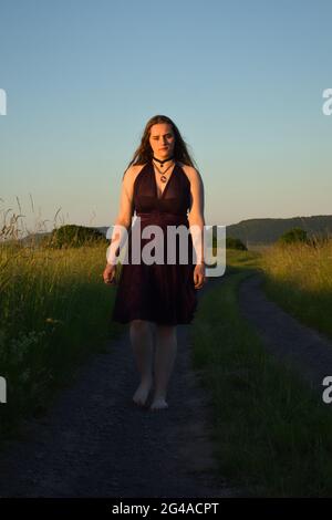 Teenage girl, 16, walking on a dirt road in rural Germany. Stock Photo