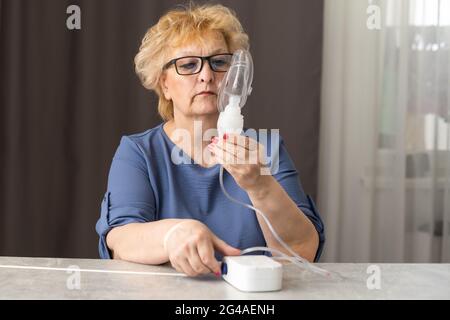 Young Female Doctor Holding Oxygen Mask Over Senior woman Patient's Face. Stock Photo